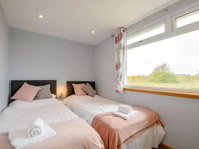 two beds in a room with a window at Sand View in Mainsriddle