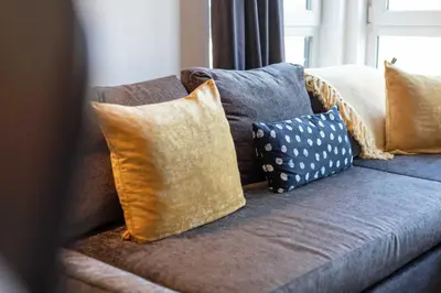 a blue couch with several pillows on it at Walker Suite No82 - Donnini Apartments in Kilmarnock