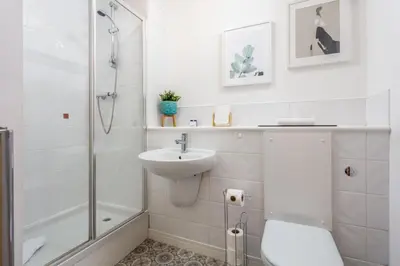a white bathroom with a sink and a shower at Walker Suite No82 - Donnini Apartments in Kilmarnock