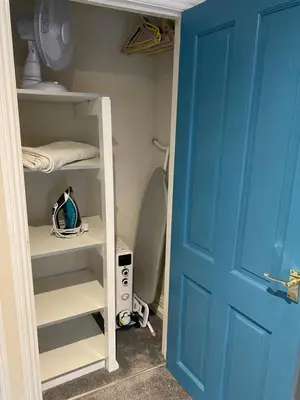a closet with a blue door next to a toilet at Kezbah2 22 the square centre of Dalston village in Dalston