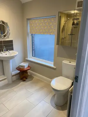 a bathroom with a toilet and a sink and a window at Kezbah2 22 the square centre of Dalston village in Dalston