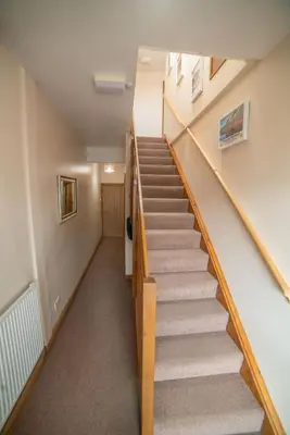 a staircase in a house with wooden railings at The Haven Keswick - Spacious Central Apartment in Keswick