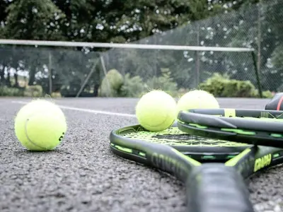 four tennis balls sitting on a tennis court at The Grooms Cottage in Mauchline