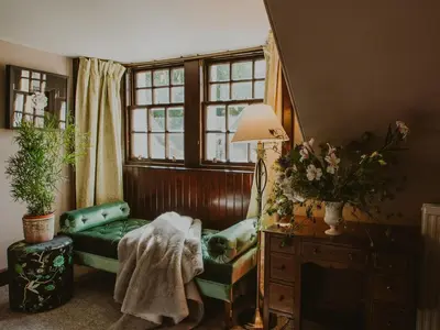 a living room with a green couch and a window at Coachman in Enoch