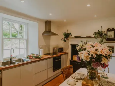a kitchen with a table with a vase of flowers at Coachman in Enoch