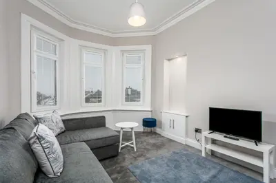 a living room with a couch and a flat screen tv at Seaforth Suite - Donnini Apartments in Ayr