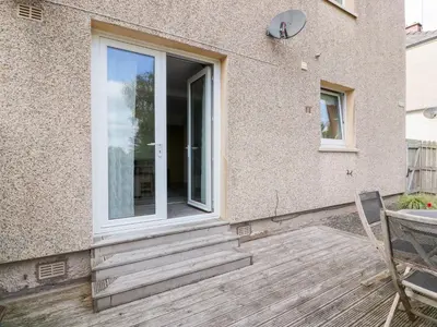 a glass door on a house with a wooden porch at Simply Suite in Castle Douglas