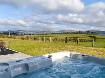 a jacuzzi tub with a view of a field at Dinduff Lodge in Challoch