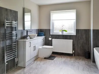 a bathroom with a toilet and a sink and a window at Dinduff Lodge in Challoch