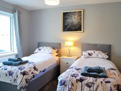 a bedroom with two beds and a window at Dinduff Lodge in Challoch