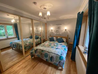 a bedroom with two beds and a mirror at Country Cottage Sleeps 6 w Hot Tub & Dog-Friendly in Moniaive