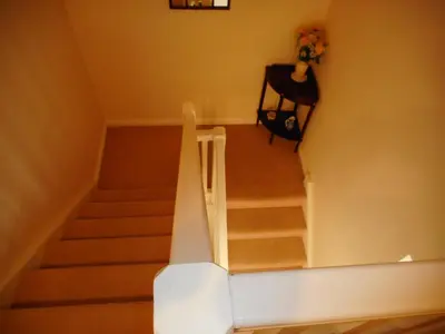 a staircase in a room with a table and flowers at DairyCottage, 5, TELFORD MEWS BEATTOCK in Moffat