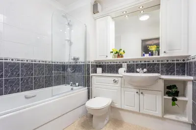 a bathroom with a toilet and a sink and a bath tub at Millbrae Residence - Donnini Apartments in Ayr