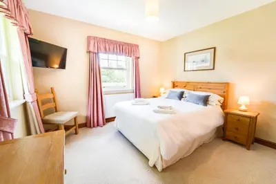 a bedroom with a large bed and a window at Briarwood House in Keswick