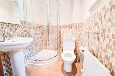 a bathroom with a shower and a toilet and a sink at Briarwood House in Keswick