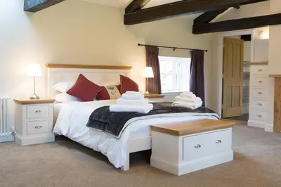 a bedroom with a large white bed with red pillows at Netherby Hall in Carlisle