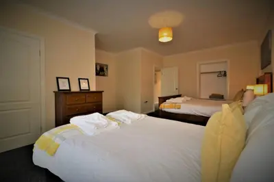 a bedroom with two beds and a dresser at Signature - Kirkhill House in Kirkmuirhill