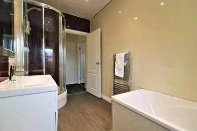 a bathroom with a tub and a sink at Signature - Kirkhill House in Kirkmuirhill