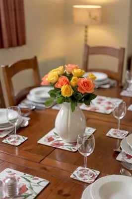 a table with a vase of flowers on a table at Balcraig House in Maybole
