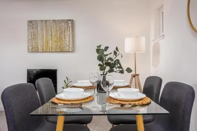a dining room with a glass table and chairs at Walker Suite No53 - Donnini Apartments in Kilmarnock