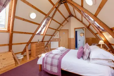 a bedroom with a large bed in a attic at Rabbie Burns Lodge in Maybole