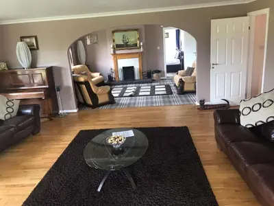a living room with couches and a glass table at Cumnock Knowes Holiday Retreat in Carsphairn