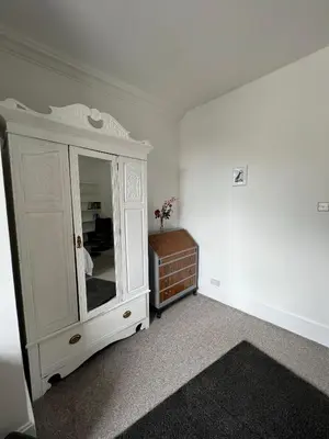a bedroom with a white cabinet and a dresser at Stylish 2nd Floor Georgian 1 Bedroom Apartment in Dumfries