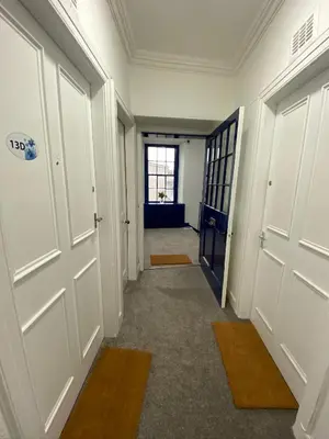 an empty hallway with white doors and a window at Stylish 2nd Floor Georgian 1 Bedroom Apartment in Dumfries