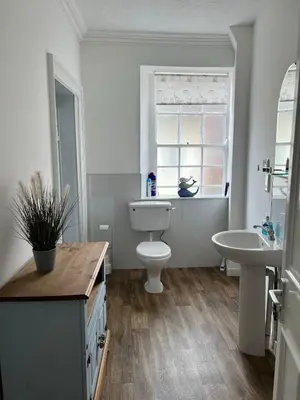 a bathroom with a toilet and a sink and a window at Stylish 2nd Floor Georgian 1 Bedroom Apartment in Dumfries