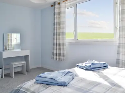 a bedroom with a bed with two towels on it at Bel-Mar in Whithorn