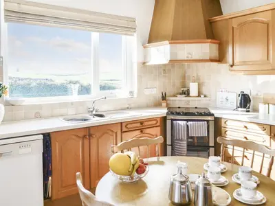 a kitchen with a table with a bowl of fruit on it at Bel-Mar in Whithorn