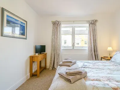 a bedroom with a bed and a tv and a window at Seacote Gardens in St Bees