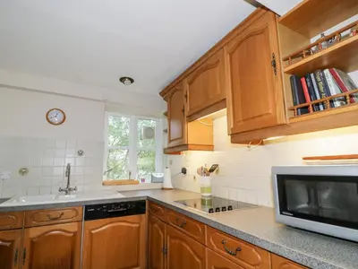 a kitchen with wooden cabinets and a microwave at Fell Foot in Holmrook