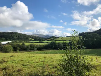 a field of green grass with mountains in the background at Fell Foot in Holmrook