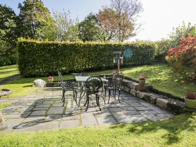 a patio with a table and chairs in a yard at Fell Foot in Holmrook