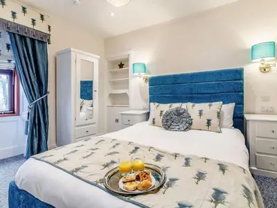 a bedroom with a bed with a tray of food on it at Golden Crown exclusive use spa venue in Tarbolton