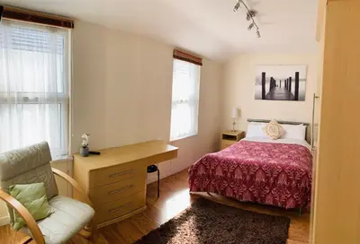 a bedroom with a bed and a desk and a chair at Cunard Apartments in Douglas