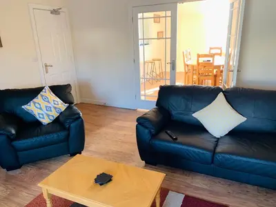 a living room with two leather couches and a table at Cunard Apartments in Douglas