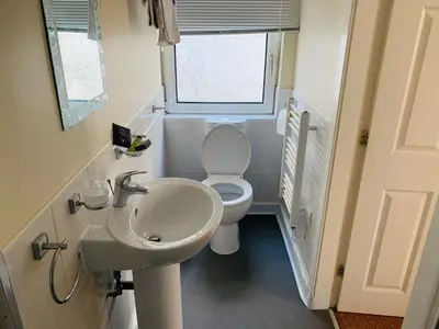 a bathroom with a white toilet and a sink at Cunard Apartments in Douglas