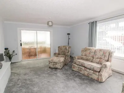 a living room with two chairs and a couch at Honesty Cottage in Girvan