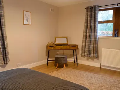 a bedroom with a desk and a window and a table at Terraughtie Cottage East-Uk31767 in Terreglestown