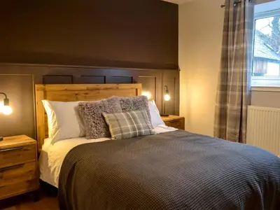a bedroom with a large bed and a window at Terraughtie Cottage East-Uk31767 in Terreglestown