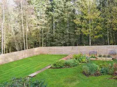 a fence in a yard with a green lawn at Glen Rosa in Ayr