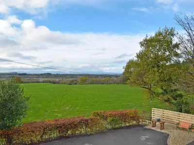 a park bench sitting in front of a green field at Glen Rosa in Ayr
