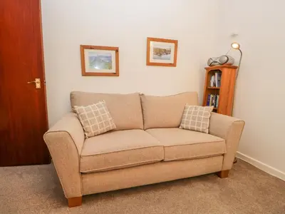 a couch sitting in a living room with two pillows at Oak View in Keswick