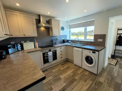 a kitchen with a washer and dryer at Garrarie Cottage in Monreith