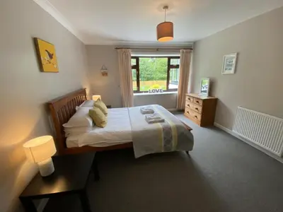 a bedroom with a bed and a window at West Lodge - Uk7137 in Newton Stewart
