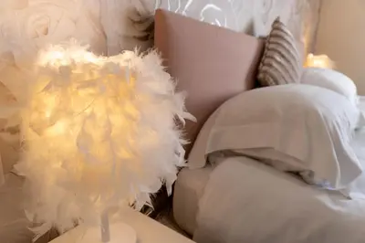a vase with feathers on a table next to a couch at Four Oaks House in Carlisle