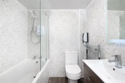 a bathroom with a shower and a toilet and a sink at Four Oaks House in Carlisle