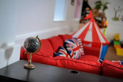 a living room with a red couch and a table with a mirror at Four Oaks House in Carlisle